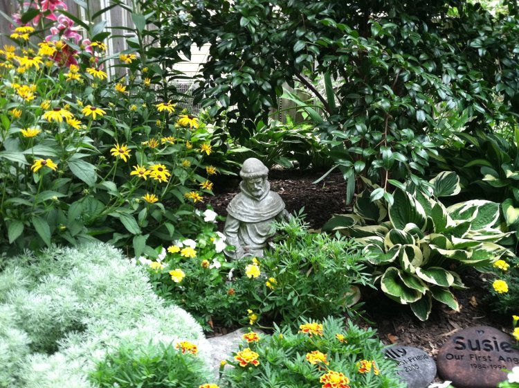 St. Francis statue watches over a flower garden in Maryland, where two beloved pets are buried. (William Thomas)